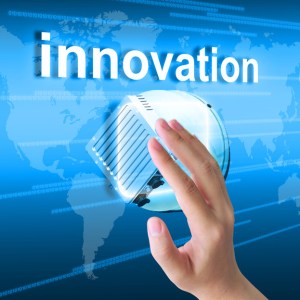 hand pushing innovation button on a touch screen interface